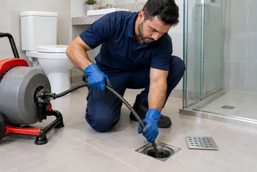 Técnico realizando desentupimento de ralo com equipamentos especializados.